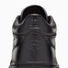 A detailed view of the CONVERSE CONS REMY TAVEIRA FASTBREAK PRO MID in black, showcasing a star emblem and a snake design on the heel, enhanced by a sleek nubuck upper for a sophisticated look.