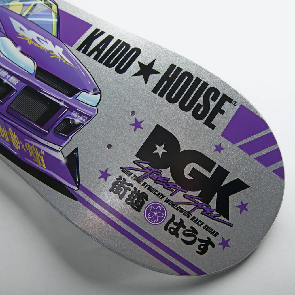 Close-up of the DGK x Kaido House Roulette Racer Silver Glitter skateboard deck, featuring a purple car graphic on a sunset twilight backdrop with "Kaido House" and "DGK" text, stars, and Japanese characters.