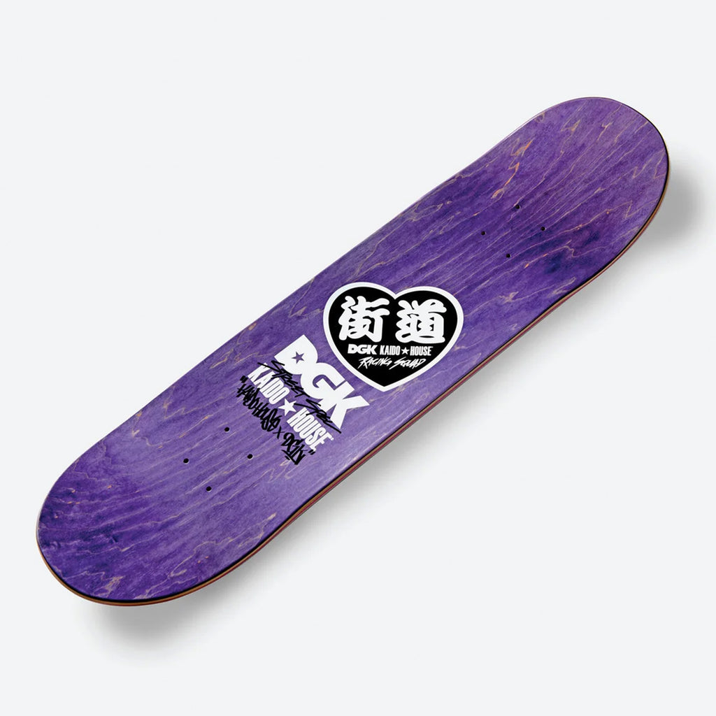 Silver glitter skateboard deck by DGK, featuring white graphics with text and logos against a backdrop similar to a sunset twilight.