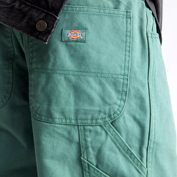 Close-up of a green Dickies Duck Canvas Carpenter Pant Dark Forest Washed pocket with a visible brand label.