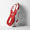 The ES éS TJ ROGERS WHITE / RED sneaker is shown from the bottom, displaying its textured, impact-resistant sole and bold logo designs in striking white with red accents.