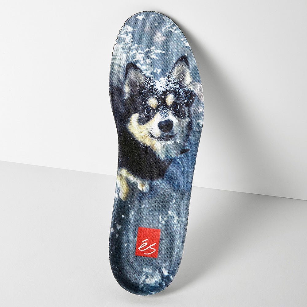 An insole for the éS TJ ROGERS BLACK / BLUE / WHITE from ES, featuring a printed dog with snow on its face and a red logo near the heel, inspired by skate shoes with durable cupsole construction.