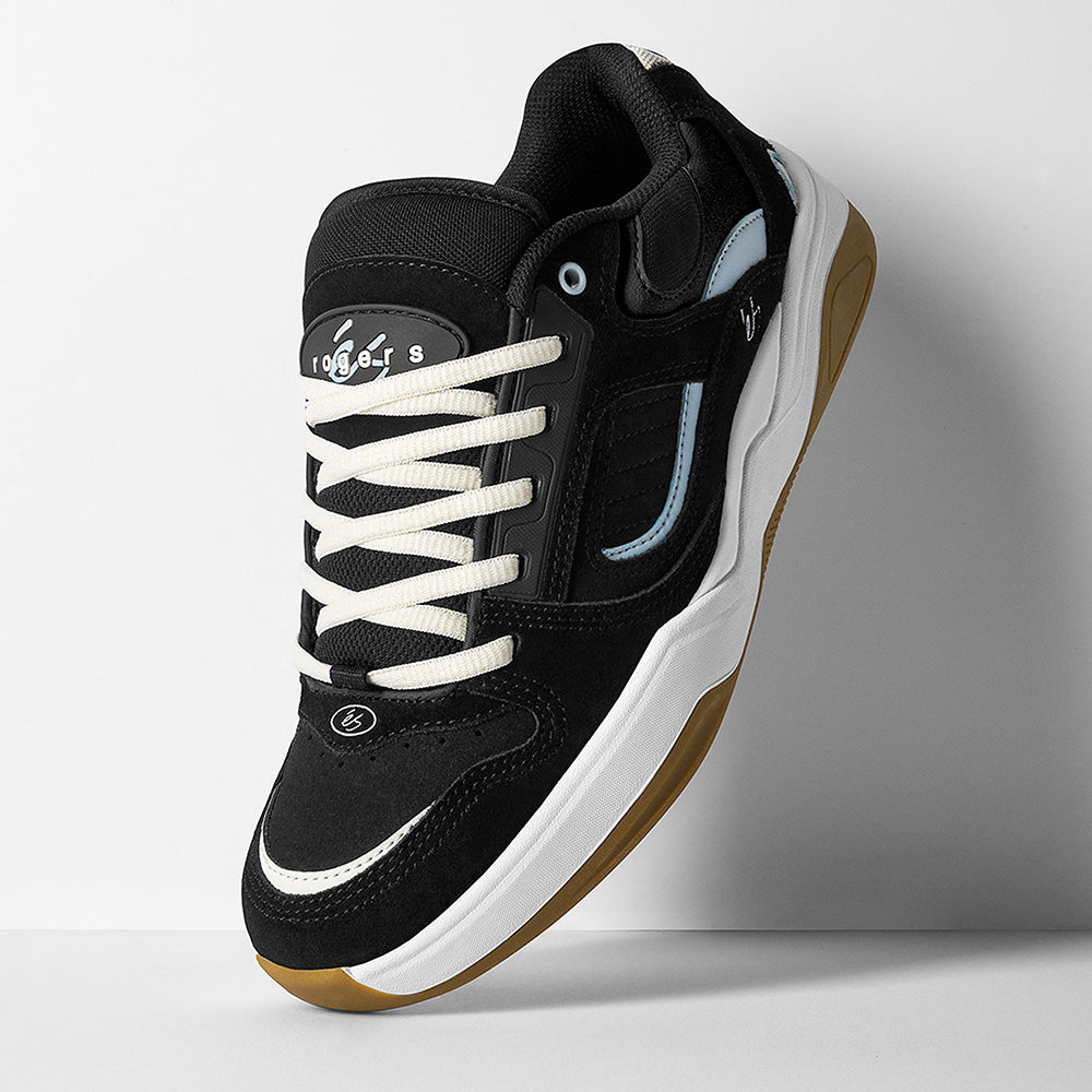 The ES éS TJ ROGERS BLACK / BLUE / WHITE skate shoe features a black and white upper with blue accents, a tan cupsole, white laces, and tongue branding, showcased against a simple background.