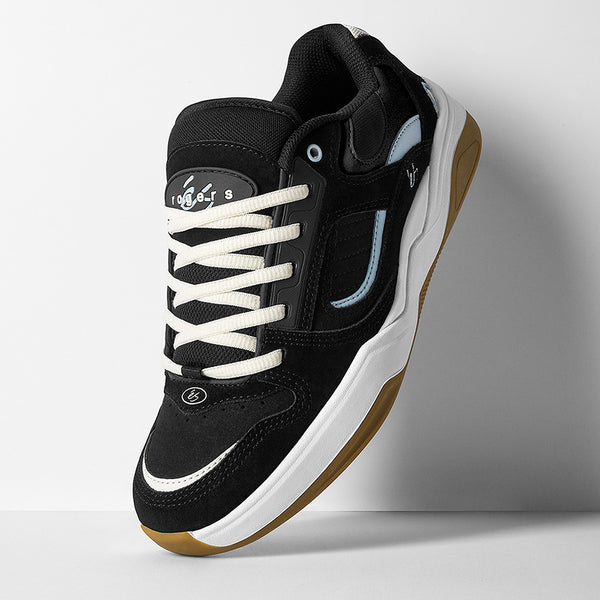 The ES éS TJ ROGERS BLACK / BLUE / WHITE skate shoe features a black and white upper with blue accents, a tan cupsole, white laces, and tongue branding, showcased against a simple background.