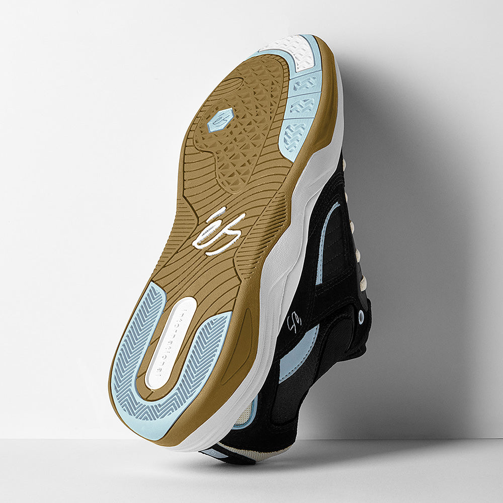 The éS TJ ROGERS BLACK / BLUE / WHITE skate shoe by ES is shown sole up, highlighting its brown, white, and light blue textured outsole with the "éS" logo—classic cupsole construction inspired by the iconic ACCEL.