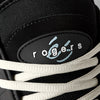 Close-up of the éS TJ ROGERS skate shoe in black, blue, and white by ES, featuring white laces, cupsole construction, and a "rogers" label with a light blue graphic.