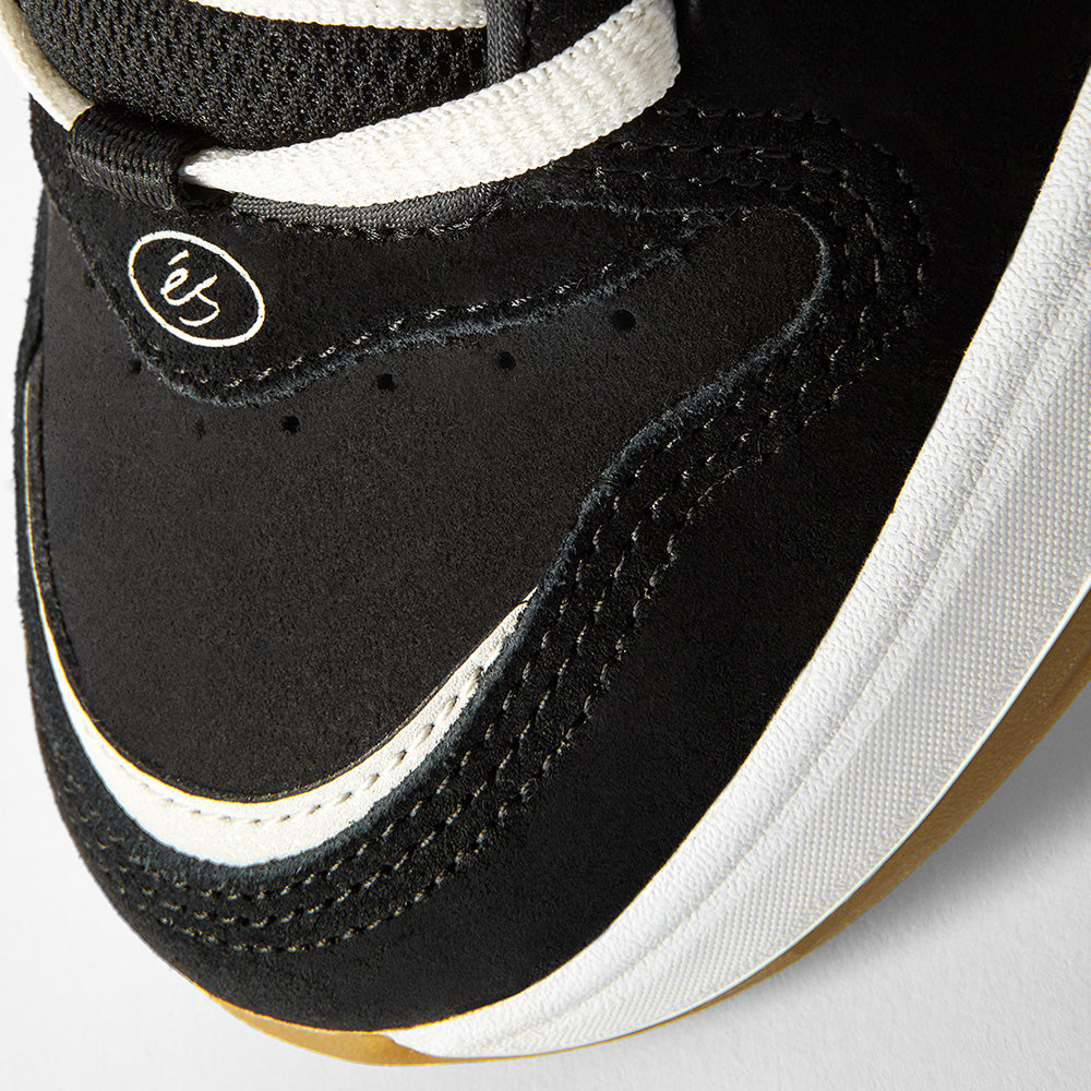 Close-up of the toe area of the ES éS TJ ROGERS BLACK / BLUE / WHITE skate shoe, featuring black suede, white stitching, a white cupsole, and a small 'éS' logo near the laces—showcasing its classic skate style.