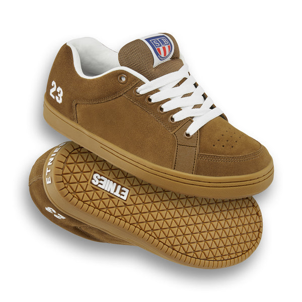 The brown and gum ETNIES SAL 23 skate shoes, adorned with white laces and soles along with "23" and "ETNIES" branding, honor Salvador Barbier.