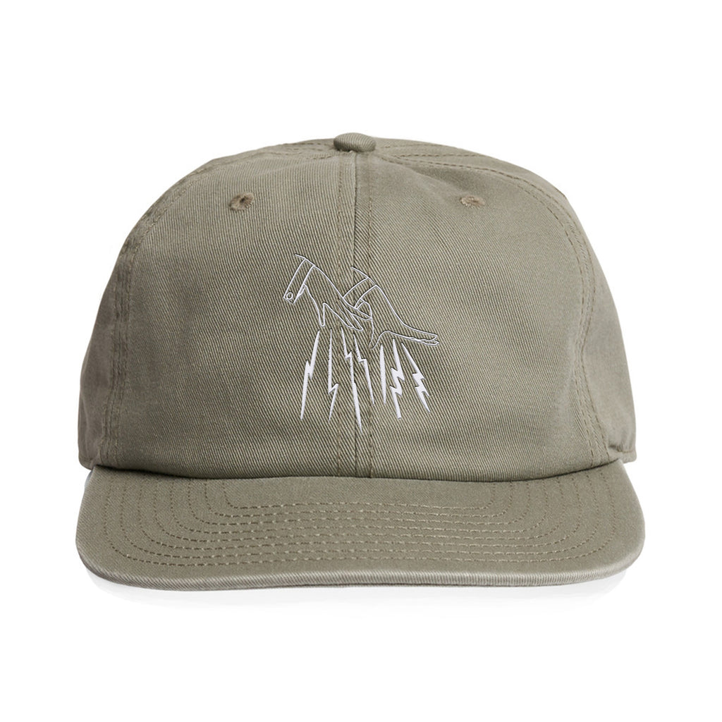 The FAKE JUNK LOGO DAD HAT EUCALYPTUS by FAKE JUNK is a khaki dad hat made from cotton, featuring a white embroidered graphic of a simplistic mountain design with lightning bolts on the front. It also includes an adjustable fastener for the perfect fit.