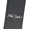 A black FAKE JUNK GRIPTAPE TRAMP STAMP MOREGRIP FORMULA sheet with "Fuke Junk" in white script at the center, made by FAKE JUNK for enhanced traction.