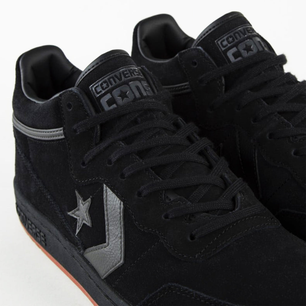 A pair of black suede CONVERSE CONS FASTBREAK PRO MID SUEDE BLACK / GREY AREA / GUM with laces, featuring the iconic star and chevron design on the sides, seen on a white background.