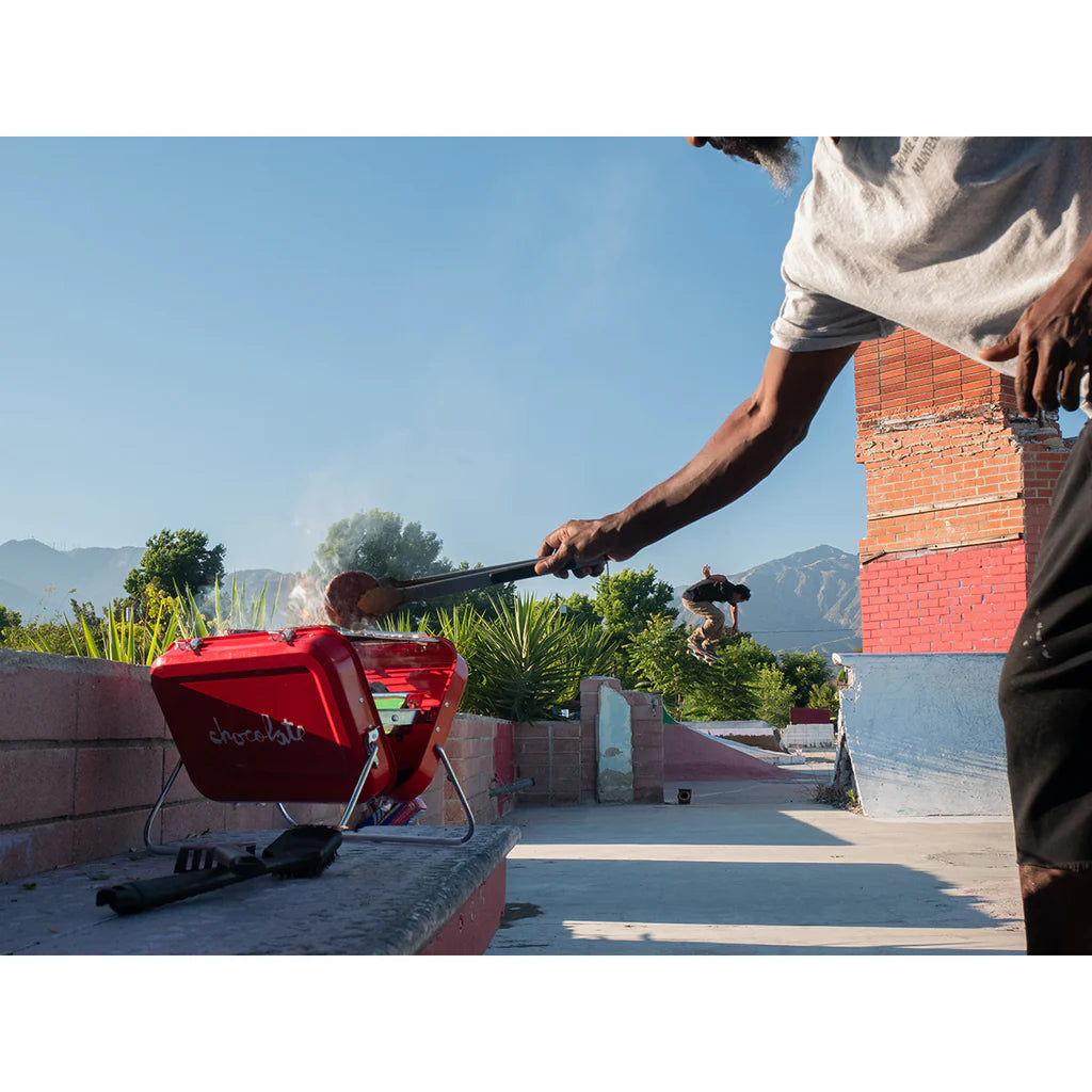 A man is grilling on a CHOCOLATE SPOT GRILL.