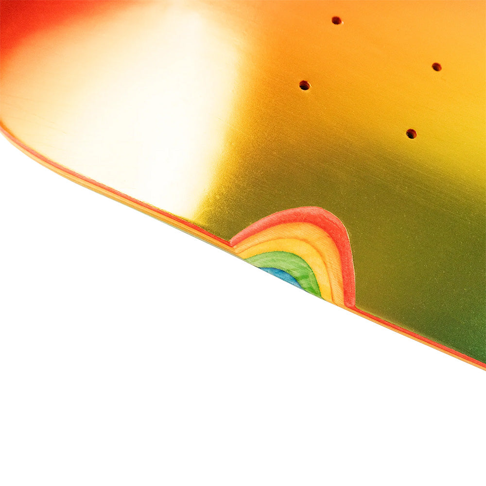 Close-up of the HARDBODY SABER RAINBOW skateboard deck by HARDBODY, featuring a metallic orange-gold finish and a small rainbow design near the edge.