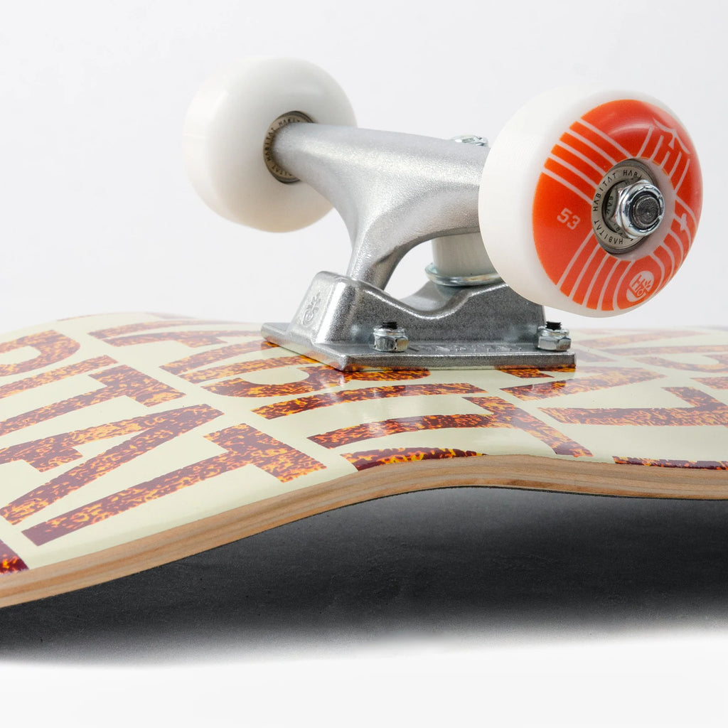 A close up of a Habitat Insecta Orange Complete skateboard with a white background.