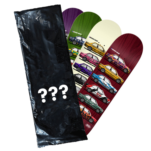 The REAL ISHOD SKATESHOP DAY BLIND BAG TT by REAL features a large black bag with question marks and three colorful skateboard decks showcasing car designs and a responsive pop.