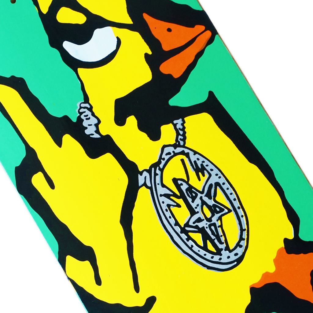 The skateboard deck art from Carpet Co., known as the "CARPET DUCK YOU KAREEM GUEST PRO," showcases a vibrant green carpet-like background with a yellow cartoon figure wearing a prominent necklace adorned with a star emblem.