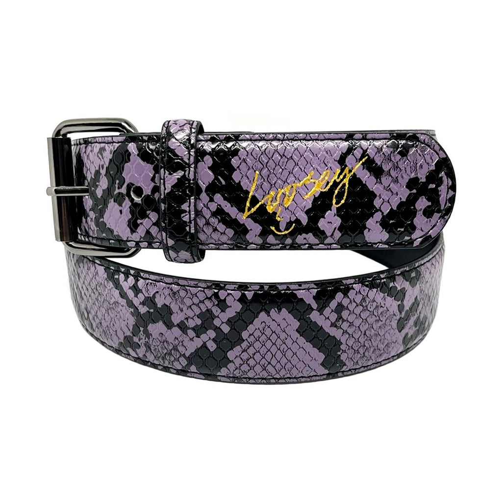 The LOOSEY SLITHER BELT PURPLE by Loosey features a striking purple and black snakeskin pattern, adorned with a gold "Legacy" inscription on the strap and completed with a sleek charcoal buckle.