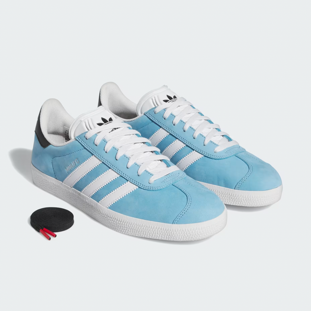 A pair of ADIDAS x MNUFC x FAMILIA Gazelle ADV shoes in Crystal White, Core Black, and Better Scarlet with a regular fit.