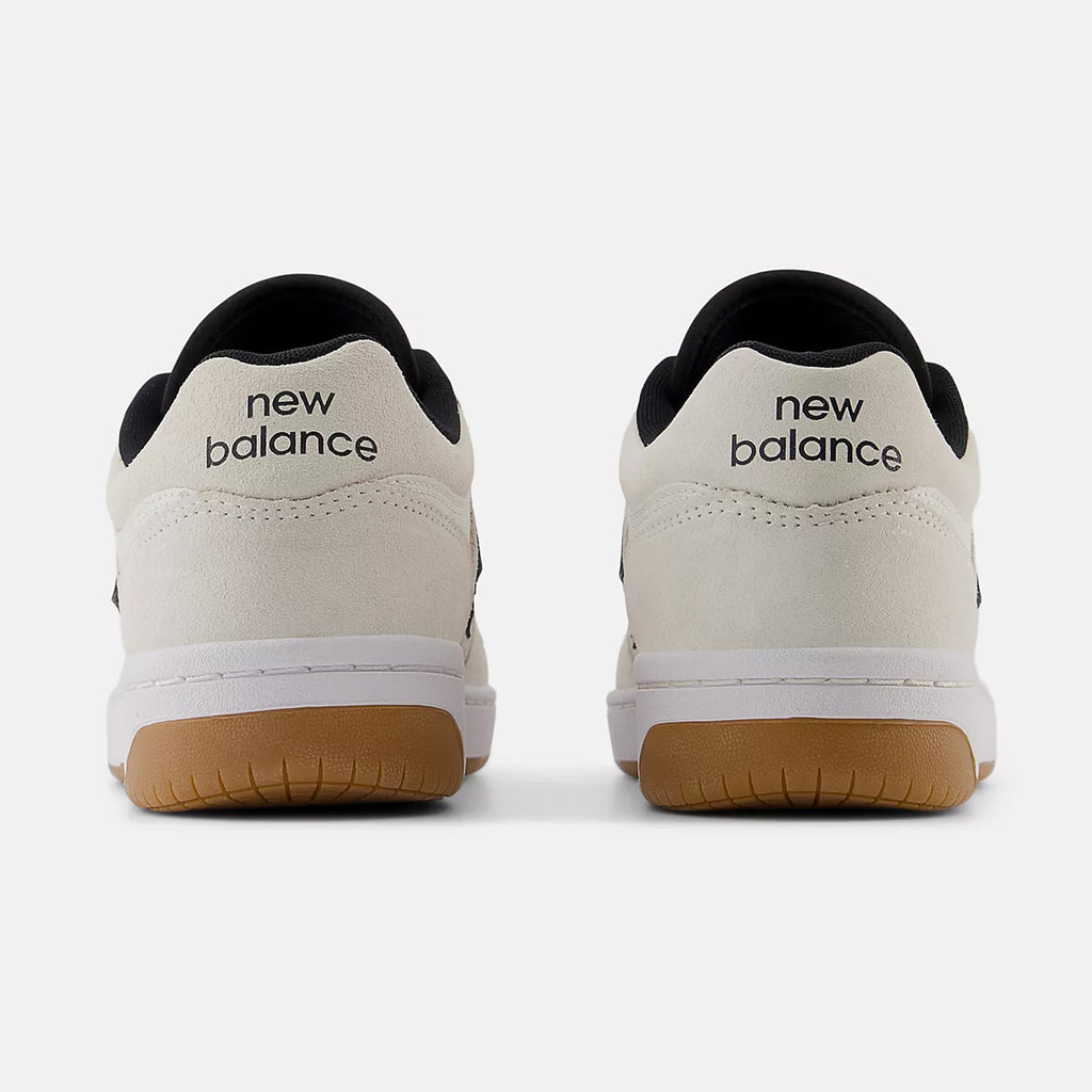 Rear view of a pair of white and black NB NUMERIC 480 WHITE / BLACK / GUM sneakers with gum soles, featuring the ABZORB in-sole for added comfort and the "NB NUMERIC" logo on the heel tabs.