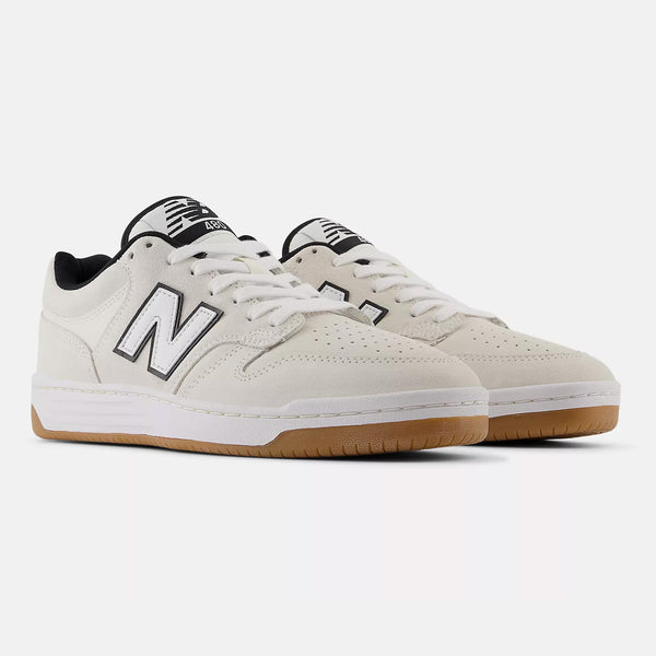 NB NUMERIC 480 WHITE / BLACK / GUM by NB NUMERIC are white athletic shoes with black accents, featuring "N" logos on the sides, gum-colored outsoles, and an ABZORB in-sole for added comfort.