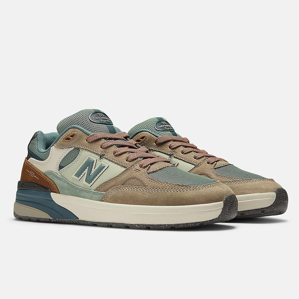 The NB NUMERIC REYNOLDS 933 in Mushroom/New Spruce features green, brown, and beige suede and mesh with the signature "N" logo and a cushioned ABZORB midsole, offering comfort inspired by classic skate shoes.