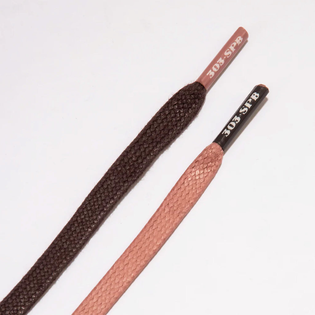 Two NB NUMERIC 480 x 303 BOARDS X JEREMY FISH shoelaces on a white background, one brown with "301 spa" in pink featuring ABZORB in-sole, the other pink with "301 spa" in black.
