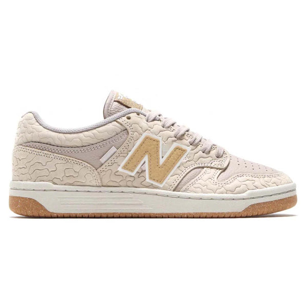 The NB NUMERIC X PREMIER 480 BROWN / WHITE sneaker channels the retro vibe of 80s and 90s skate shoes, featuring a tan color with a textured pattern, a beige "N" logo on the side, and a brown sole. It also includes a reinforced toe cap for enhanced durability.