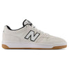 A white NB NUMERIC sneaker with a black "N" logo on the side, black accents, and a light brown gum sole, inspired by heritage hightop basketball shoes. The specific model is NB NUMERIC 480 WHITE / BLACK / GUM.