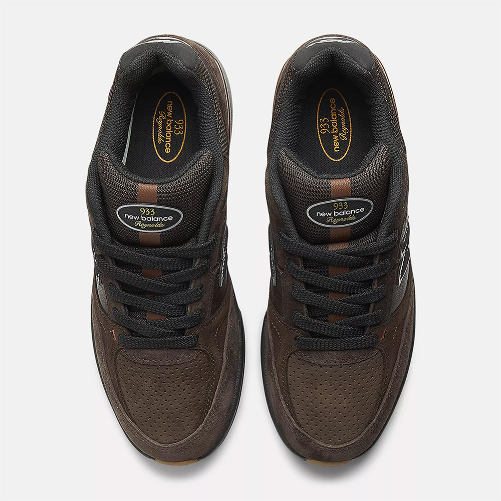 A pair of NB NUMERIC REYNOLDS 933 sneakers in brown/black, viewed from above, with black laces, brand logos on the tongues and insoles, and a cushioned ABZORB midsole for all-day comfort.
