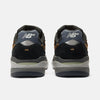 Rear view of NB NUMERIC REYNOLDS 933 CASTLEROCK / VINTAGE INDIGO sneakers in black, grey, and brown with ABZORB cushioning, featuring the NB NUMERIC logo and detailed heels against a white background.