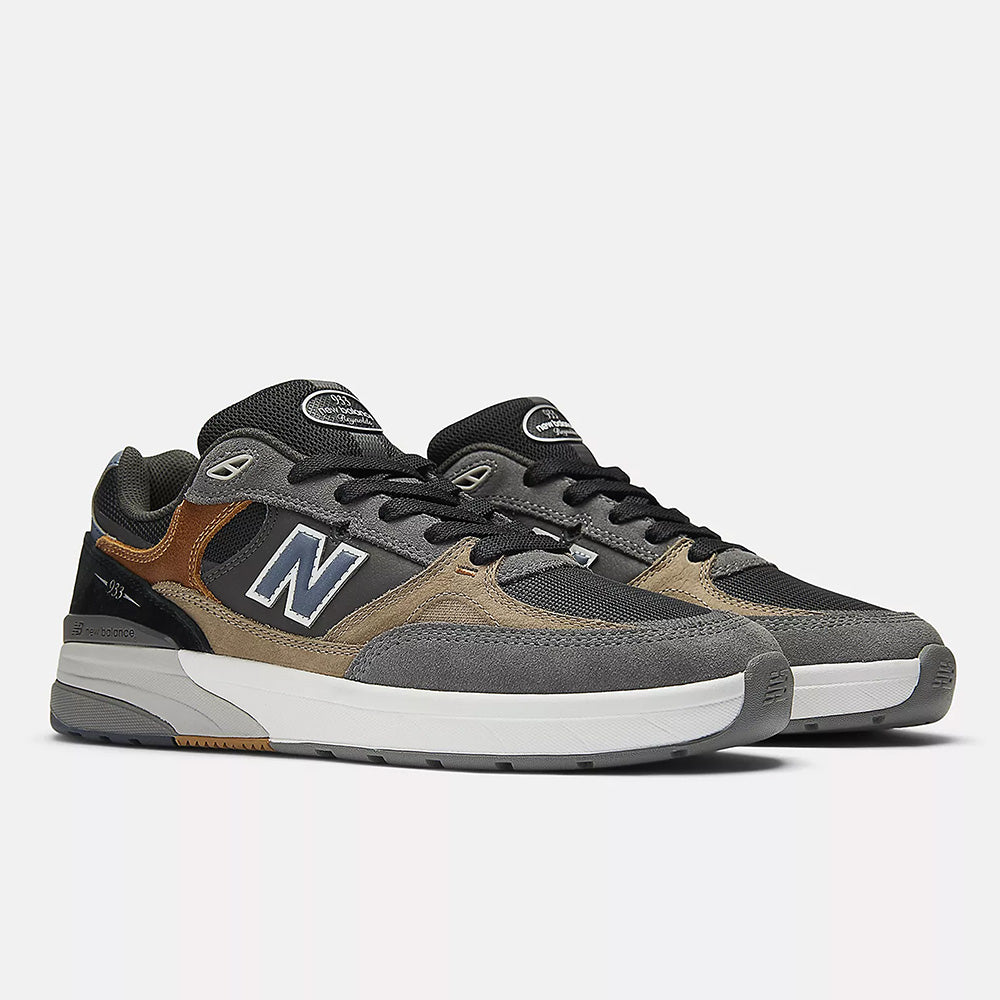 A pair of NB NUMERIC REYNOLDS 933 CASTLEROCK / VINTAGE INDIGO skate shoes by NB NUMERIC, featuring gray, black, and brown tones with white ABZORB midsoles, displayed on a plain light background.