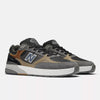 A pair of NB NUMERIC REYNOLDS 933 CASTLEROCK / VINTAGE INDIGO skate shoes by NB NUMERIC, featuring gray, black, and brown tones with white ABZORB midsoles, displayed on a plain light background.