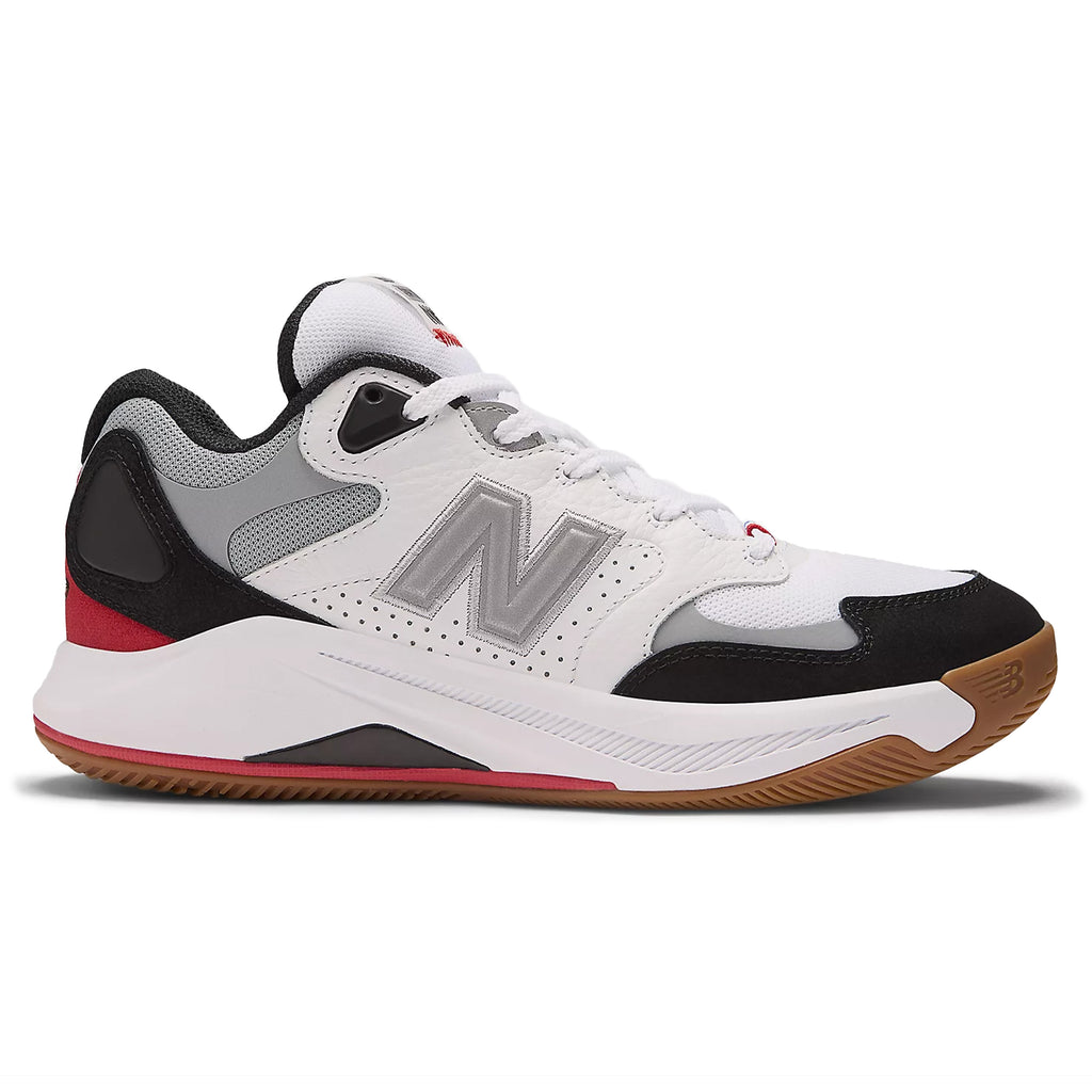 A white and black NB Numeric KAWHI 4 x Tiago athletic shoe with red accents, featuring a FuelCell midsole and a gum-colored sole, viewed from the side against a white background.