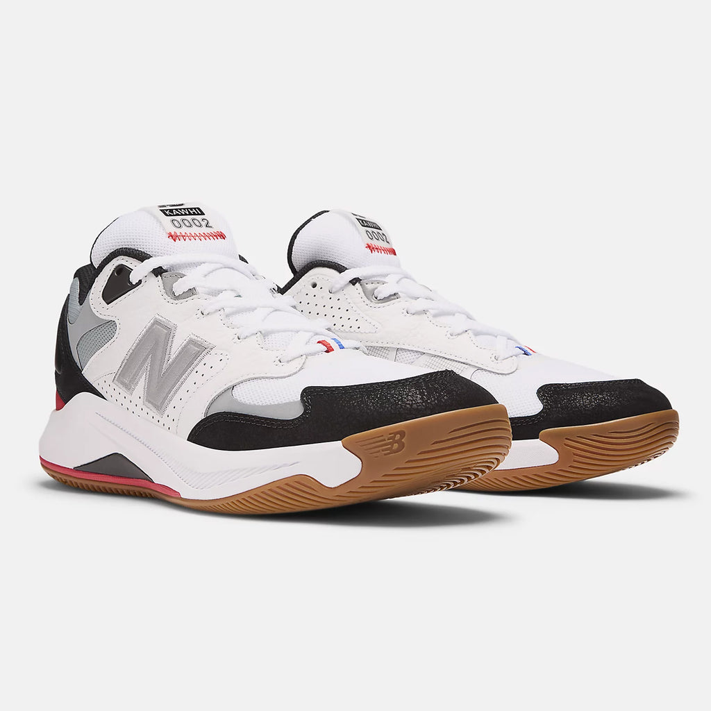 A pair of NB NUMERIC KAWHI 4 X TIAGO sneakers in white and black, featuring gum soles, the New Balance logo on the sides, branded patches on the tongues, and a FuelCell midsole for added comfort.