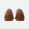 Rear view of a pair of NB Numeric NB NUMERIC X MUSEUM 272 WHEAT / BROWN suede sneakers with white accents and red tags labeled "MUSEUM" on the back.