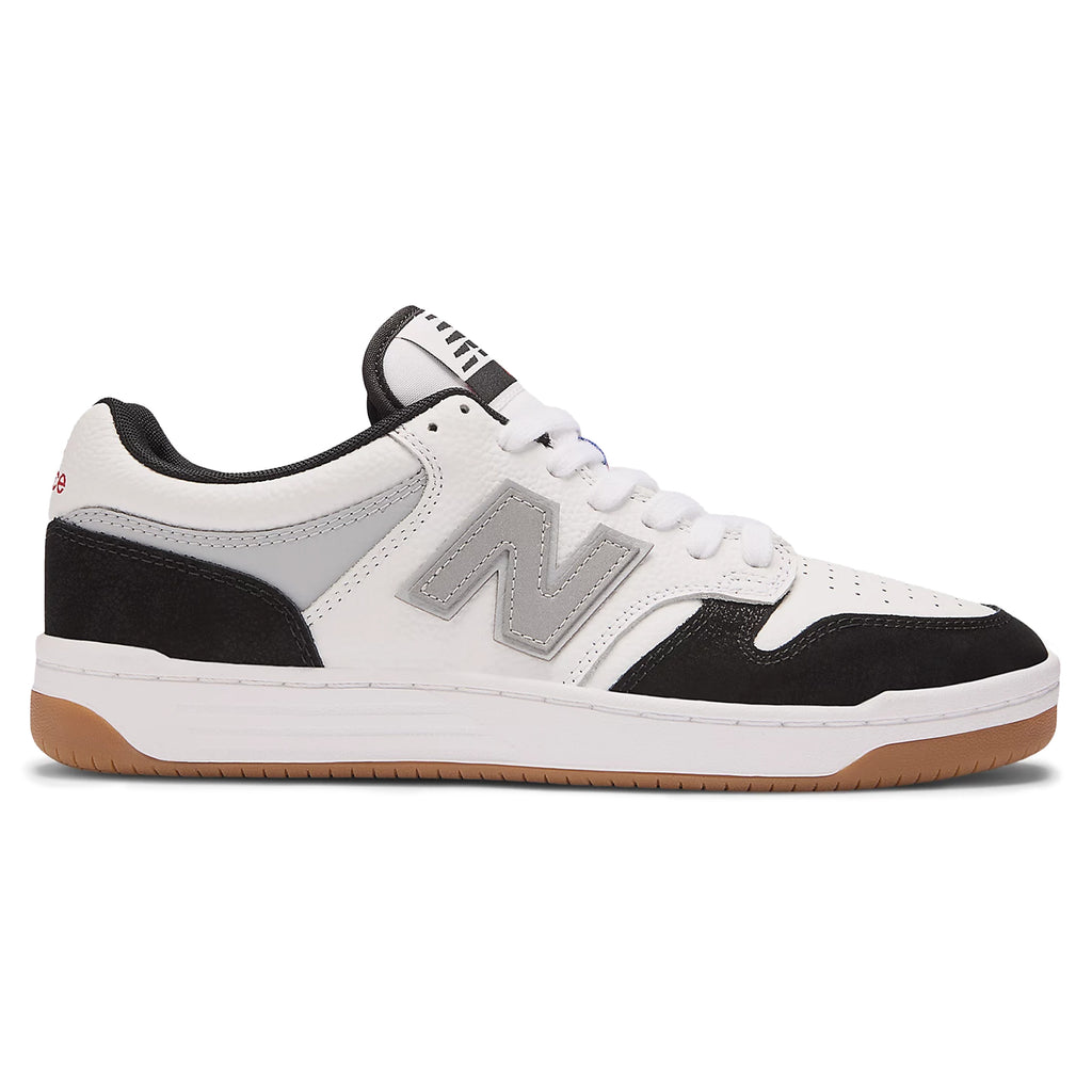 From a side view, the NB NUMERIC 480 TIAGO X KAWHI WHITE / BLACK sneaker showcases a design in black, white, and gray with a gum sole and boasts the iconic "N" on the side. The shoe incorporates ABZORB in-sole technology to ensure superior comfort.