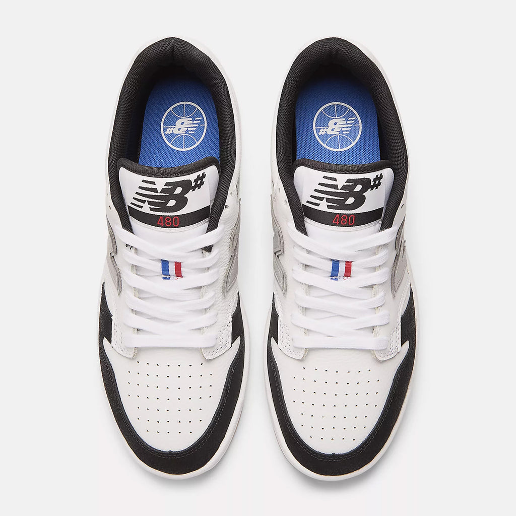 Top view of a pair of NB Numeric 480 Tiago x Kawhi sneakers in white with black and blue accents, showcasing the New Balance logo on the tongue and side. These heritage hightop basketball shoes are designed for comfort with ABZORB insoles.