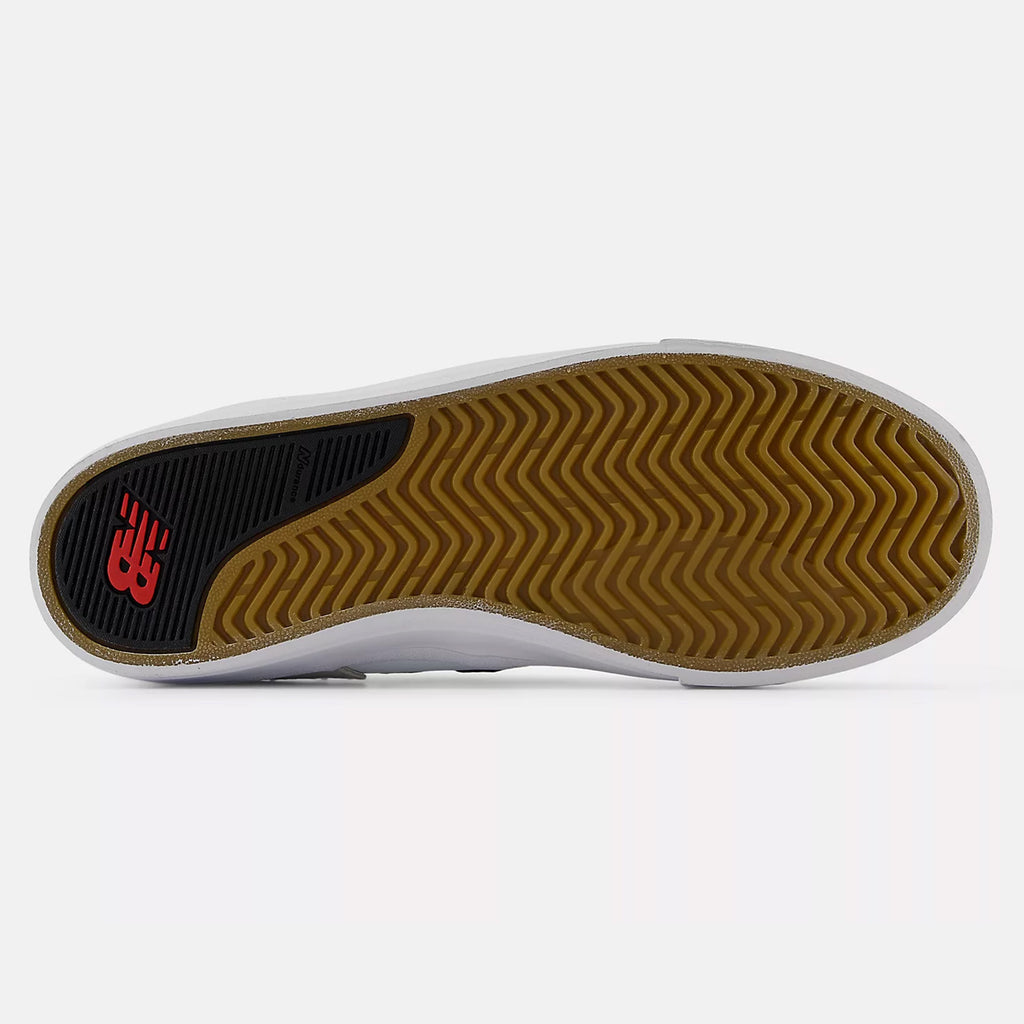 Bottom view of an NB NUMERIC NB NUMERIC FOY 306 WHITE / RED shoe displaying a yellow, wavy-grip rubber sole with a red and black logo near the heel.