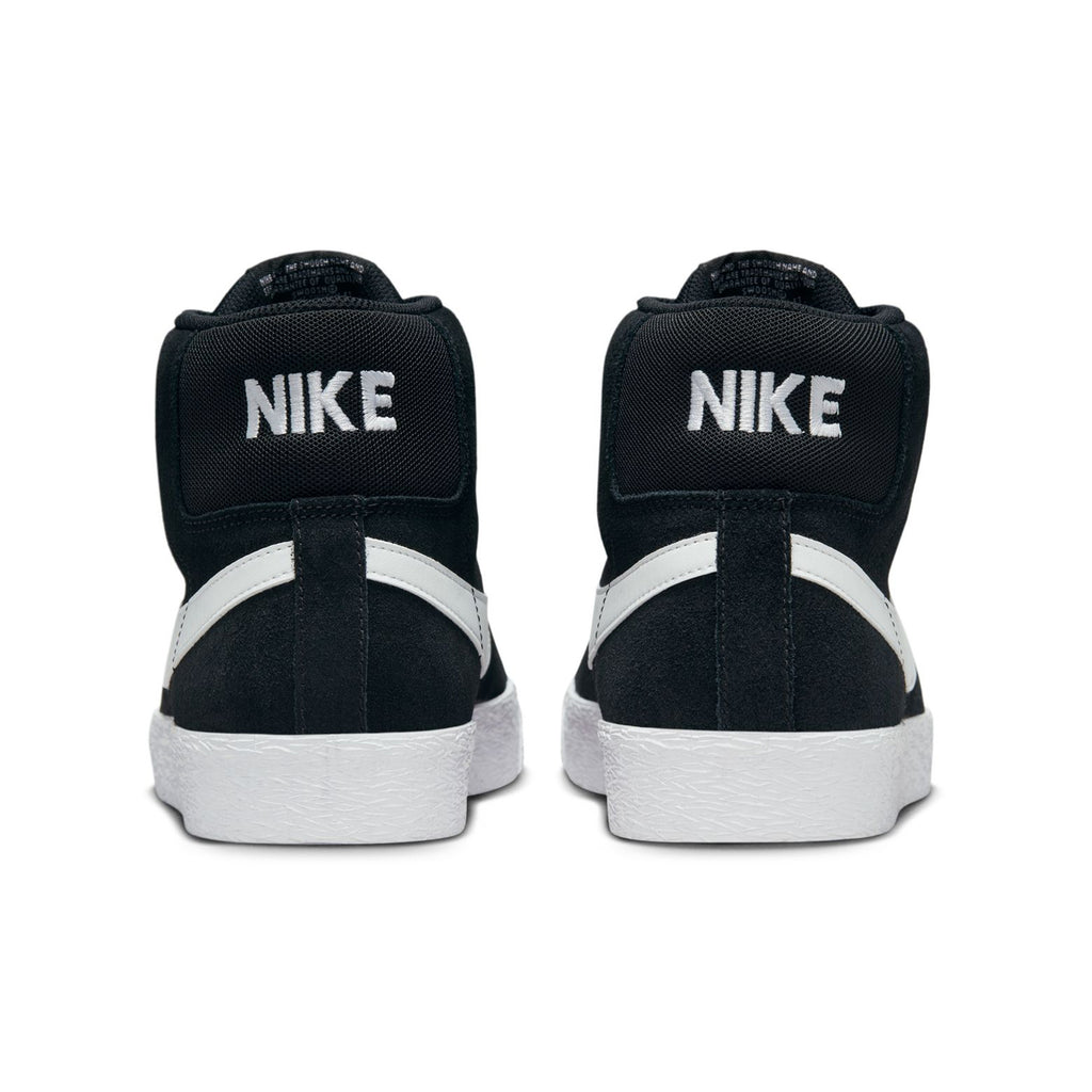 Rear view of a pair of black NIKE SB BLAZER MID BLACK / WHITE sneakers with white soles, the word "NIKE" tastefully printed in white on the back. These versatile skateboarding shoes from nike feature Zoom Air cushioning for enhanced comfort and performance.