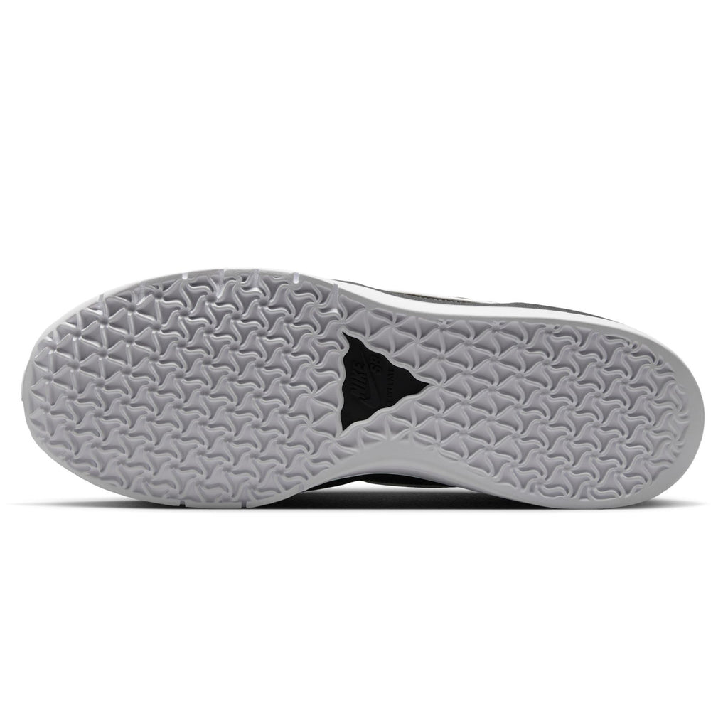 Bottom view of the NIKE SB PS8 BLACK / WHITE sneaker by Nike, showcasing a textured sole with triangular and diamond patterns, enhanced by Air Zoom cushioning for superior comfort.