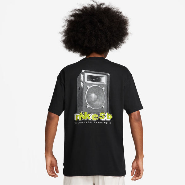 A person with an afro hairstyle is wearing a midweight black cotton NIKE SB SOUNDS BANGIN SKATE TEE by Nike, featuring a graphic of a boombox and the text "Nike SB" on the back.