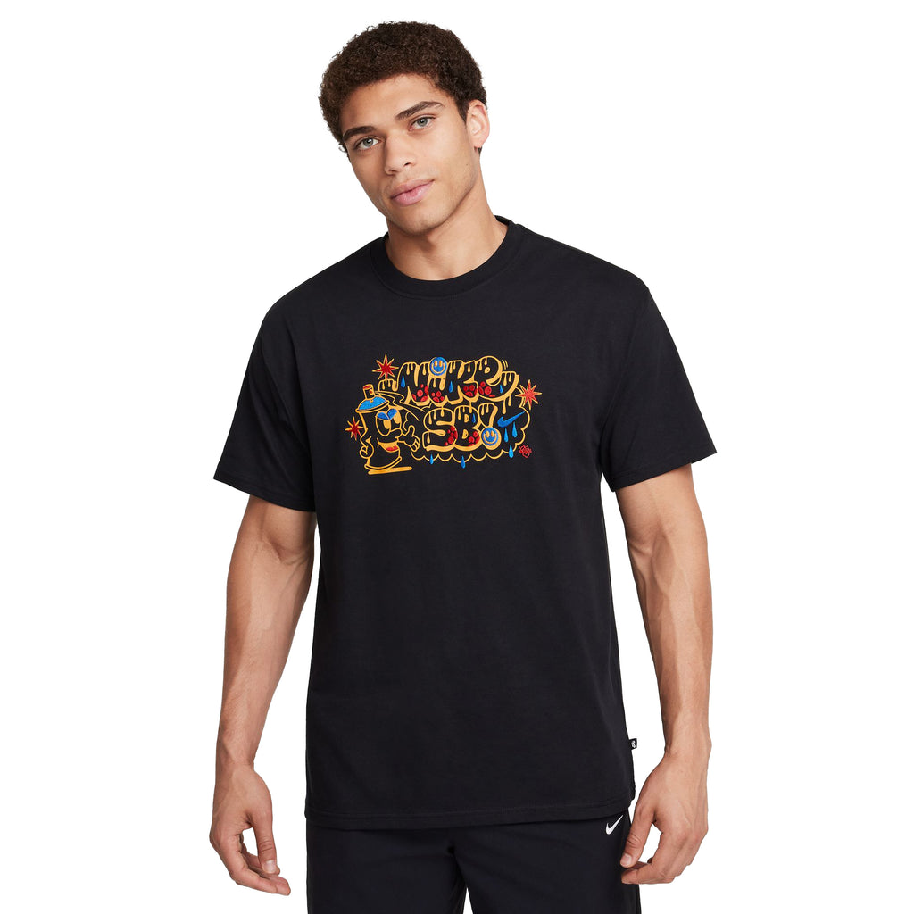 Person in a black NIKE SB MAX90 Spray Can Skate Tee, featuring vibrant "Nike Sports" graphics on lightweight cotton for a relaxed fit, standing against a plain white background.