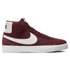 A NIKE SB BLAZER MID BURGUNDY CRUSH / SUMMIT WHITE sneaker with a suede upper, white swoosh, and sole, viewed from the side.