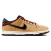 The NIKE SB DUNK LOW PRO CELESTIAL GOLD/BLACK-DARK TEAM RED offers a tan sneaker with a textured suede upper, highlighted by a black swoosh, maroon laces, and an elegant white and brown sole.