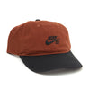 The NIKE SB CLUB HAT CINNAMON by nike is a brown and black cotton twill cap with a curved brim, front Nike SB logo embroidery, and an adjustable back strap for a comfortable fit.