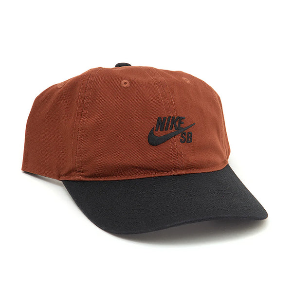 The NIKE SB CLUB HAT CINNAMON by nike is a brown and black cotton twill cap with a curved brim, front Nike SB logo embroidery, and an adjustable back strap for a comfortable fit.