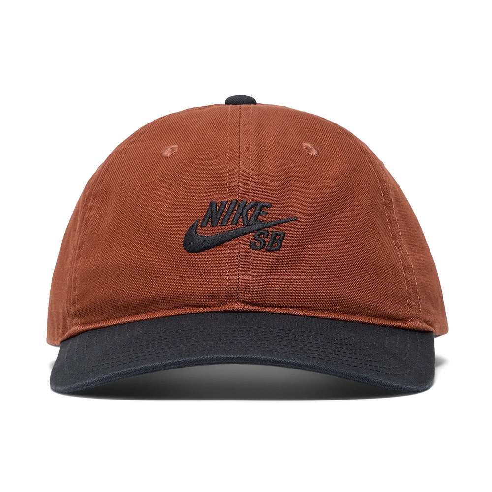 The NIKE SB CLUB HAT CINNAMON by Nike is a cotton twill cap in brown, featuring a black brim, black embroidered Nike SB logo on the front, and an adjustable back strap for a customizable fit.