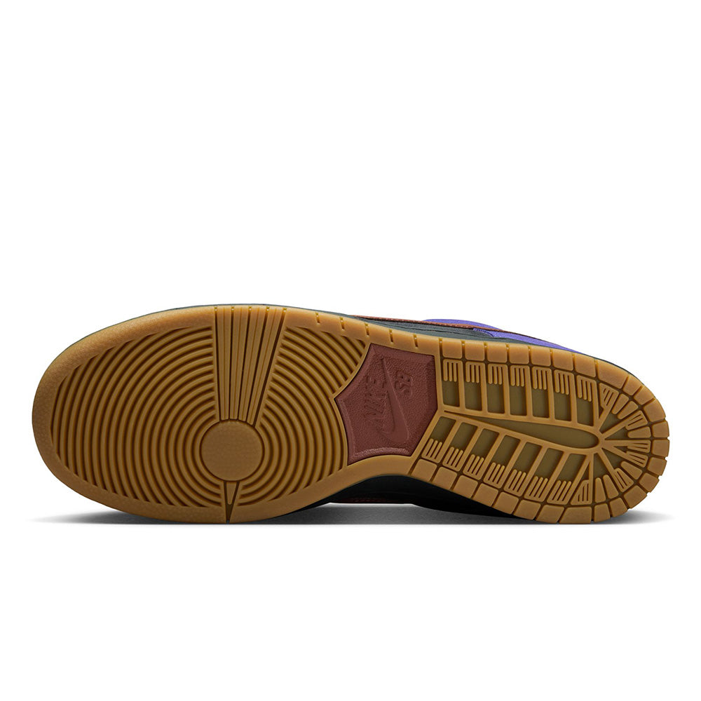 The image shows the outsole of the NIKE SB DUNK LOW PRO PERSIAN VIOLET / OFF NOIR sneaker by Nike, featuring a gum sole, circular tread pattern, and maroon hexagonal Nike logo—perfect for Bluetile Skateboards fans.