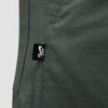 Close-up of a vintage green fabric with a visible seam and a small black tag displaying the Nike SB logo, showcasing the stylish design of Nike SB Kearny Cargo Skate Pants.