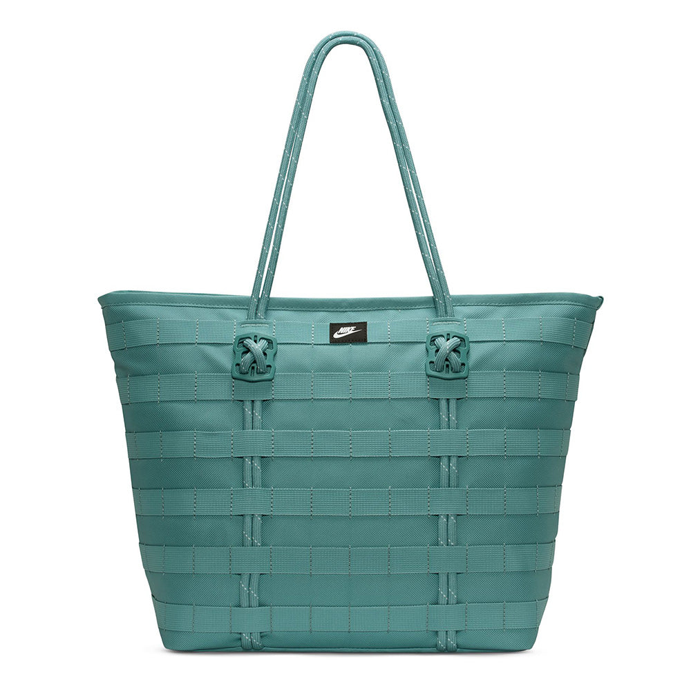 The NIKE RPM Tote (26L) in Denim Turquoise/Black/Summit White features two shoulder straps, a front black Nike logo tag, and is crafted from recycled polyester—ideal as a stylish laptop tote.